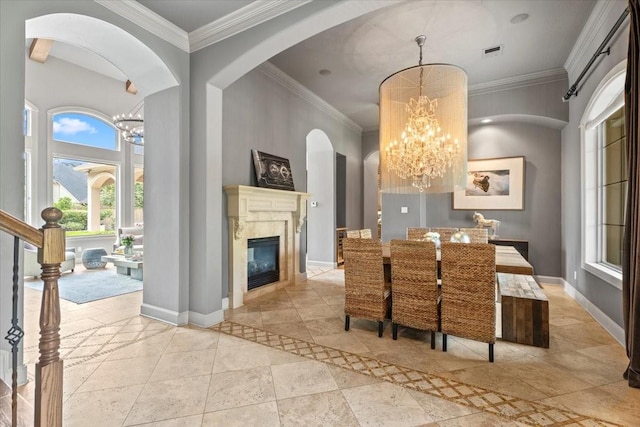 dining area with visible vents, baseboards, a fireplace, ornamental molding, and a chandelier