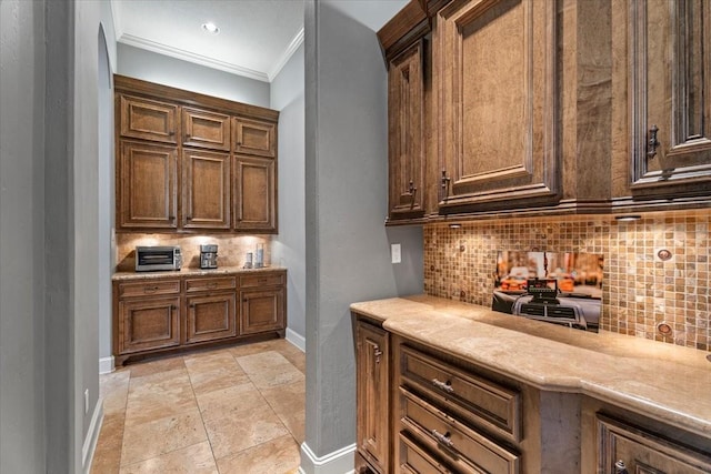 kitchen with crown molding, tasteful backsplash, light countertops, and baseboards