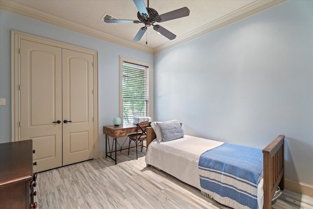 bedroom with ceiling fan, a closet, ornamental molding, and light wood finished floors