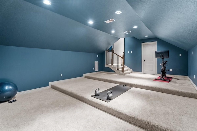 exercise room with a textured ceiling, recessed lighting, carpet flooring, baseboards, and vaulted ceiling