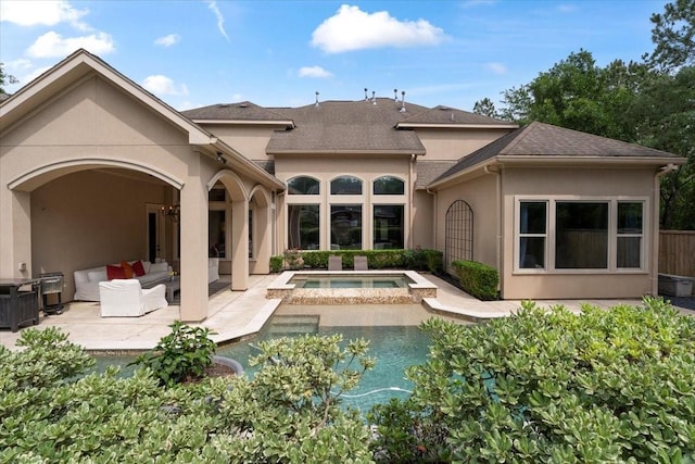 rear view of property with stucco siding, an outdoor living space, a shingled roof, an in ground hot tub, and a patio area