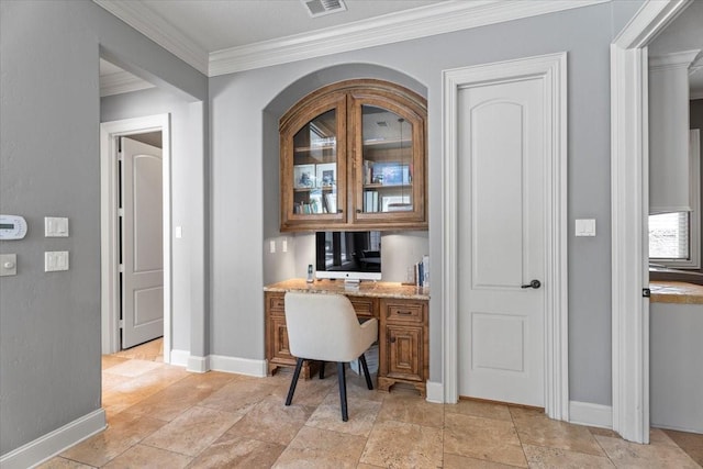 home office with visible vents, baseboards, ornamental molding, stone tile floors, and built in desk