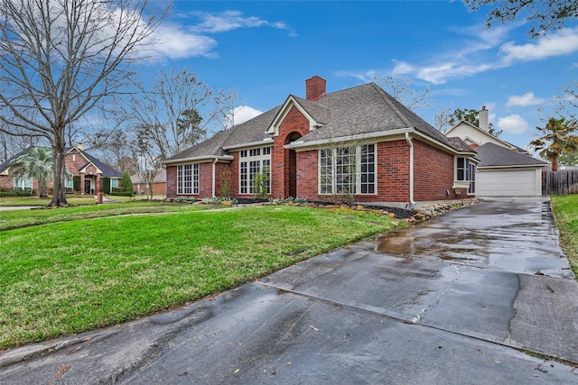 view of front of property with brick siding, a chimney, a front lawn, and roof with shingles