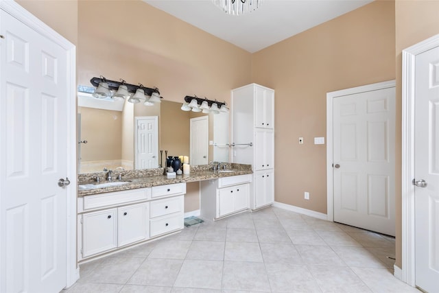 full bathroom featuring double vanity, tile patterned floors, baseboards, and a sink