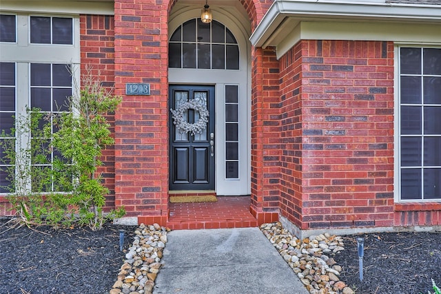 doorway to property featuring brick siding