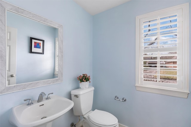 bathroom featuring a sink, toilet, and a healthy amount of sunlight