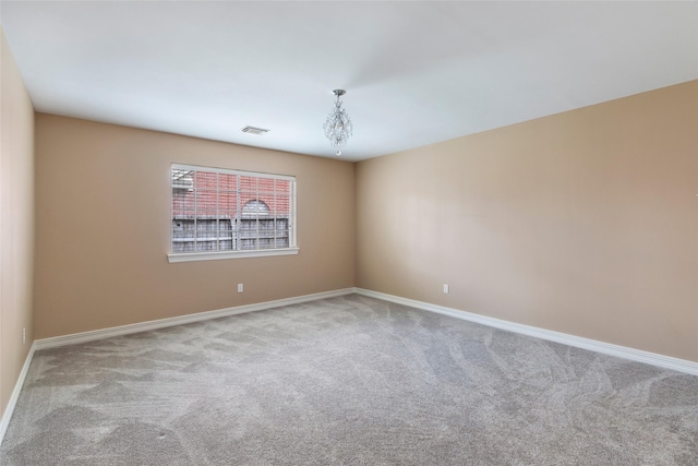 spare room with visible vents, baseboards, and carpet flooring