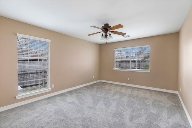 carpeted empty room featuring visible vents, baseboards, and a ceiling fan