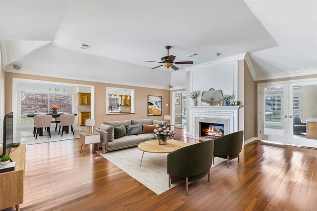 living area featuring visible vents, a high end fireplace, crown molding, ceiling fan, and hardwood / wood-style floors