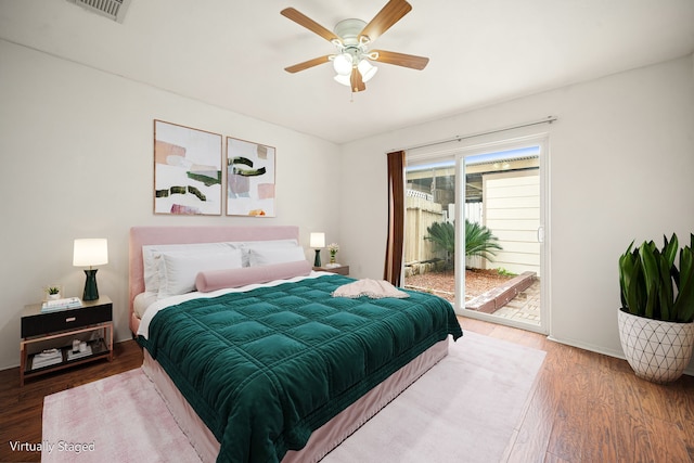 bedroom with ceiling fan, wood finished floors, visible vents, baseboards, and access to exterior