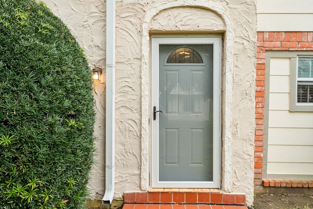 doorway to property featuring brick siding