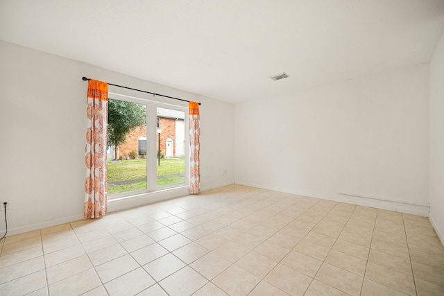 empty room featuring visible vents, baseboards, and light tile patterned flooring