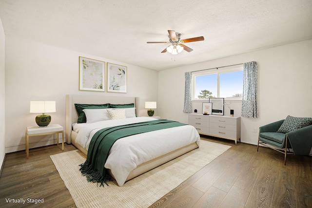 bedroom featuring ceiling fan, a textured ceiling, baseboards, and wood finished floors