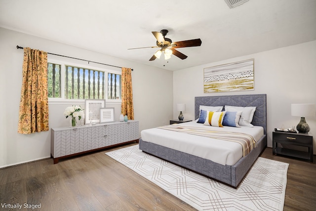 bedroom with ceiling fan, wood finished floors, and visible vents