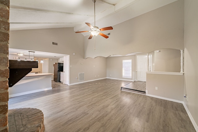 unfurnished living room featuring baseboards, visible vents, ceiling fan, and wood finished floors