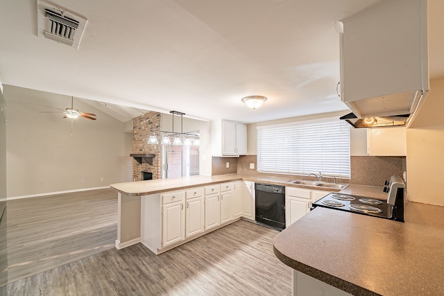 kitchen featuring lofted ceiling, visible vents, a sink, a peninsula, and black appliances