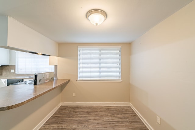 kitchen with baseboards, black dishwasher, white cabinets, backsplash, and dark wood-style floors