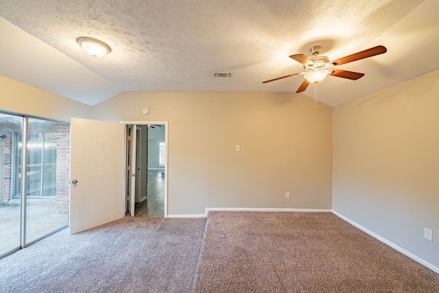 carpeted empty room featuring visible vents, a ceiling fan, vaulted ceiling, a textured ceiling, and baseboards