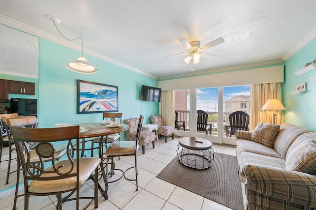 living area featuring light tile patterned floors, ornamental molding, a textured ceiling, and a ceiling fan