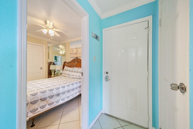 entrance foyer featuring tile patterned flooring, ceiling fan, and crown molding