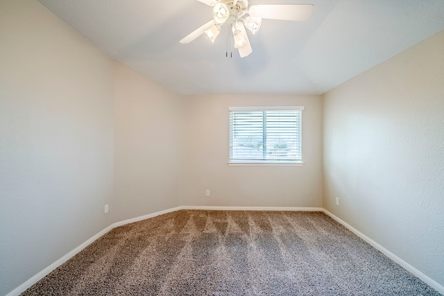 carpeted empty room with vaulted ceiling, ceiling fan, and baseboards