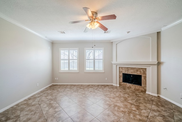 unfurnished living room with ceiling fan, ornamental molding, a textured ceiling, and a tile fireplace