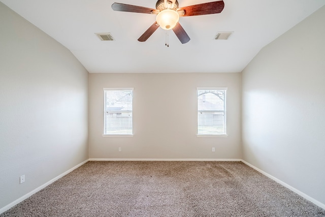 carpeted spare room with lofted ceiling, visible vents, ceiling fan, and baseboards