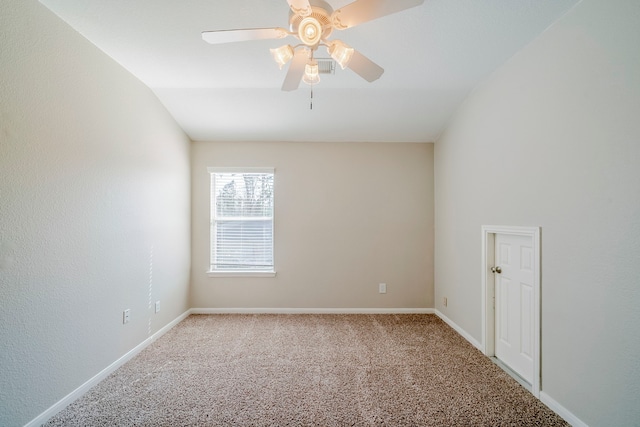 carpeted empty room featuring vaulted ceiling, ceiling fan, and baseboards