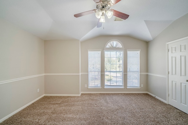 spare room with lofted ceiling, carpet, a ceiling fan, and baseboards