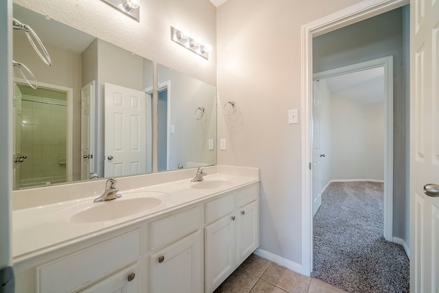 full bathroom featuring double vanity, tile patterned flooring, a sink, and baseboards