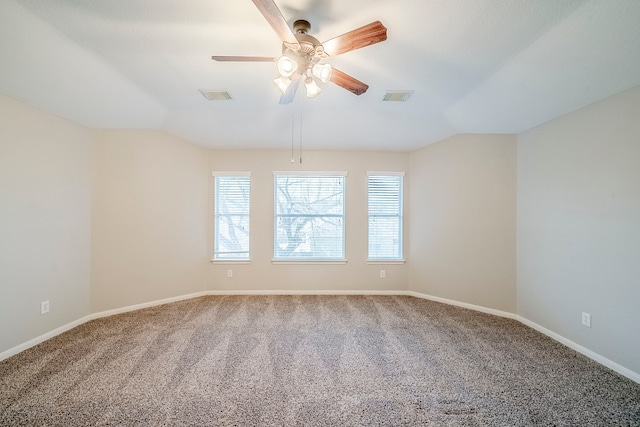 carpeted spare room with visible vents, vaulted ceiling, and baseboards