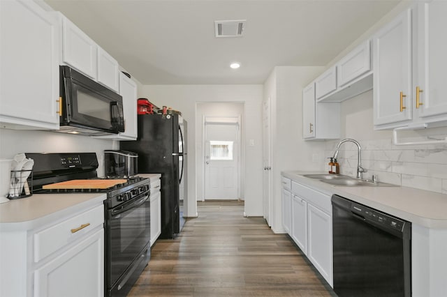 kitchen with visible vents, decorative backsplash, light countertops, black appliances, and a sink