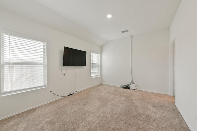 carpeted empty room featuring lofted ceiling, visible vents, and recessed lighting