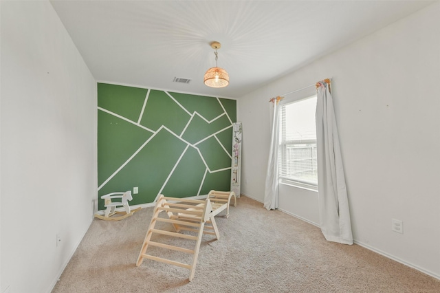 game room with baseboards, an accent wall, visible vents, and carpet flooring