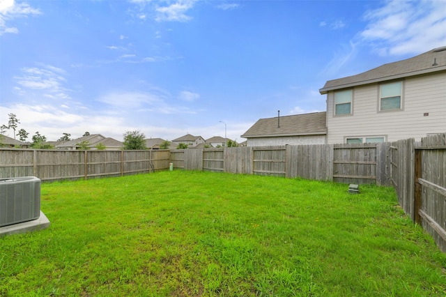 view of yard with central AC and a fenced backyard