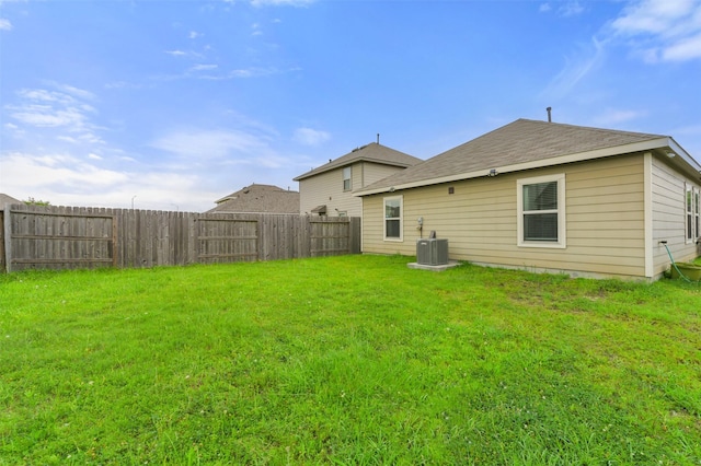 back of property featuring a yard, cooling unit, and fence