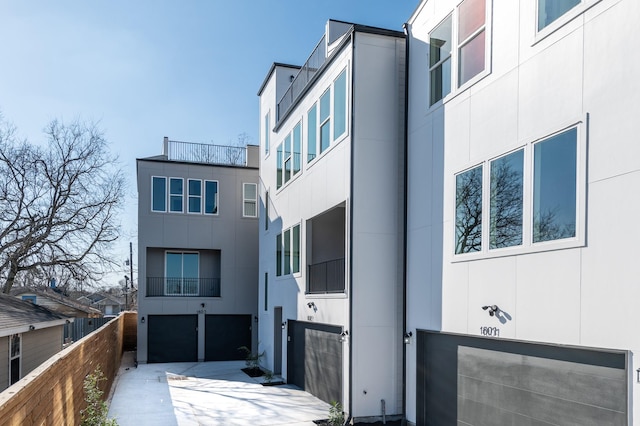 view of building exterior with a garage and fence