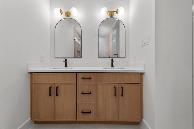 full bathroom with double vanity, a sink, and baseboards