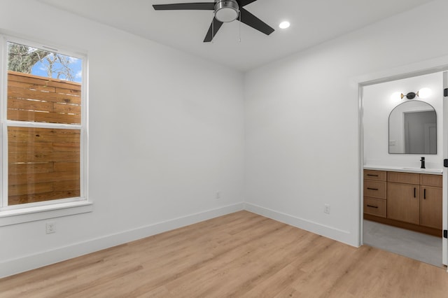 unfurnished bedroom featuring ensuite bathroom, recessed lighting, a sink, baseboards, and light wood-style floors