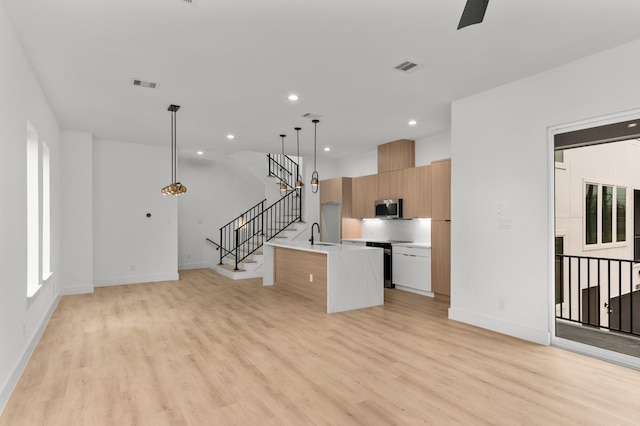 kitchen featuring stainless steel appliances, visible vents, light countertops, light wood-type flooring, and modern cabinets