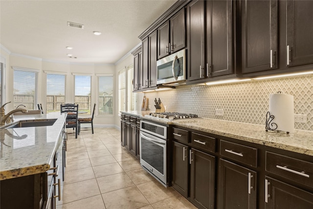 kitchen featuring light tile patterned floors, visible vents, appliances with stainless steel finishes, ornamental molding, and a sink