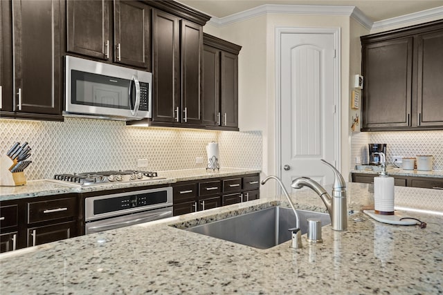 kitchen with stainless steel appliances, decorative backsplash, ornamental molding, a sink, and light stone countertops