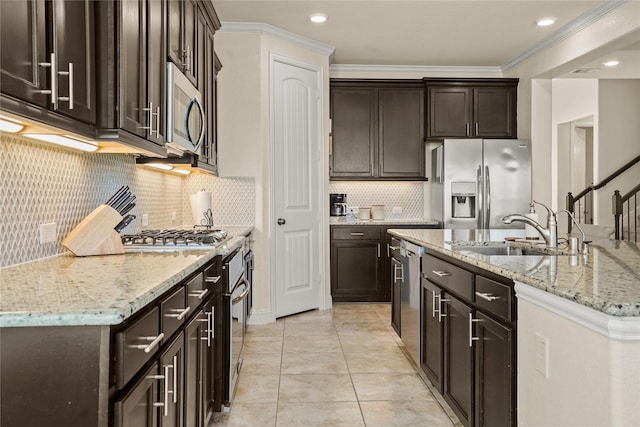 kitchen with dark brown cabinetry, appliances with stainless steel finishes, light stone countertops, crown molding, and a sink