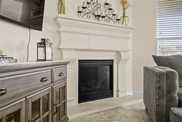 interior details featuring a glass covered fireplace and baseboards