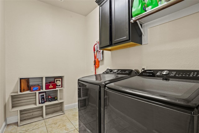 laundry area featuring baseboards, cabinet space, washing machine and clothes dryer, and light tile patterned flooring