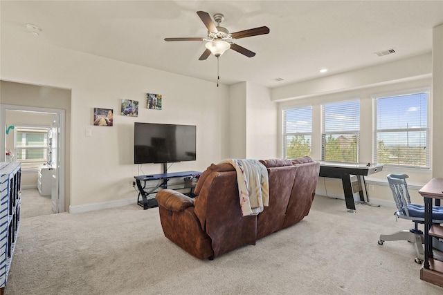 living area with a ceiling fan, light carpet, visible vents, and baseboards