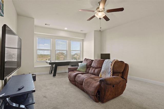 living area with light carpet, ceiling fan, visible vents, and baseboards