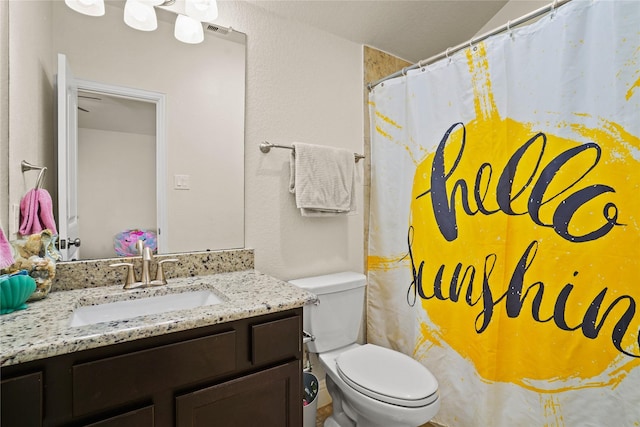 bathroom featuring toilet, curtained shower, and vanity