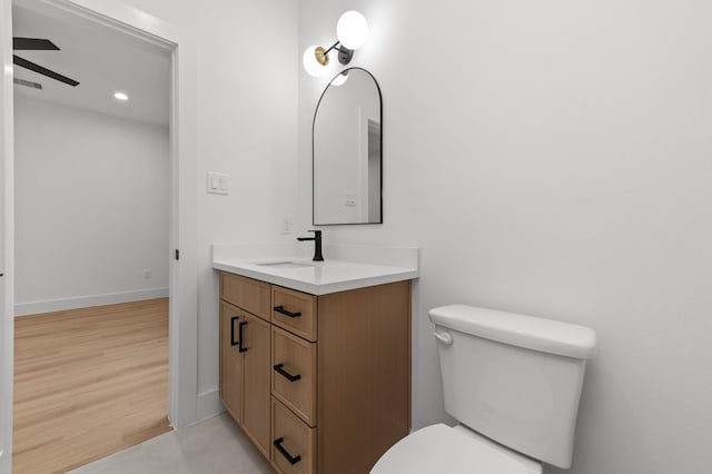 bathroom with baseboards, vanity, toilet, and wood finished floors