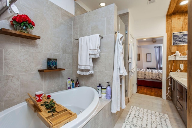 ensuite bathroom with a bath, a shower stall, tile patterned floors, and vanity